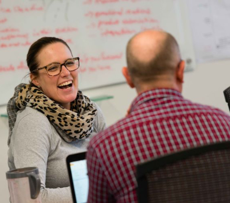 laughing woman looking toward a man