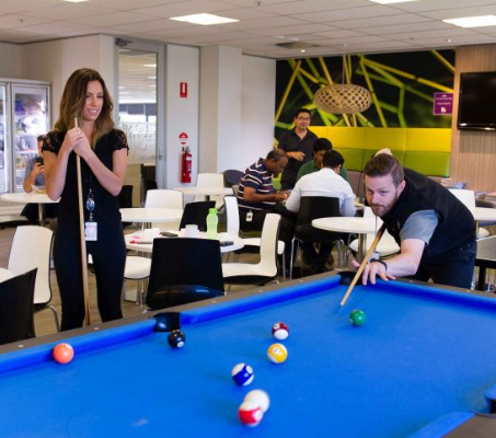 two ADP associates playing billiards in a break room