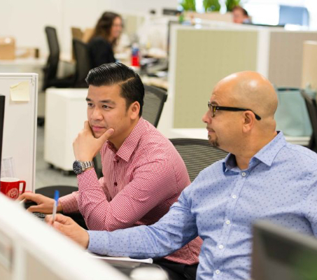 two ADP associates looking at a computer monitor