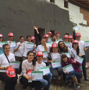 group of volunteer ADP associates in white T-shirts and red hardhats