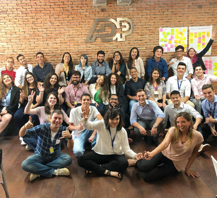 large group of ADP LatAm associates seated on the floor and chairs