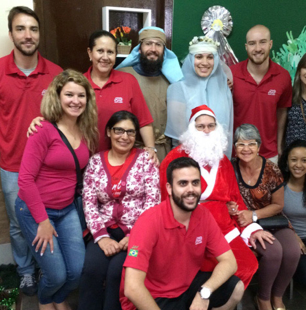 ADP associates dressed in red shirts posed around Santa Claus and the Biblical Mary and Joseph