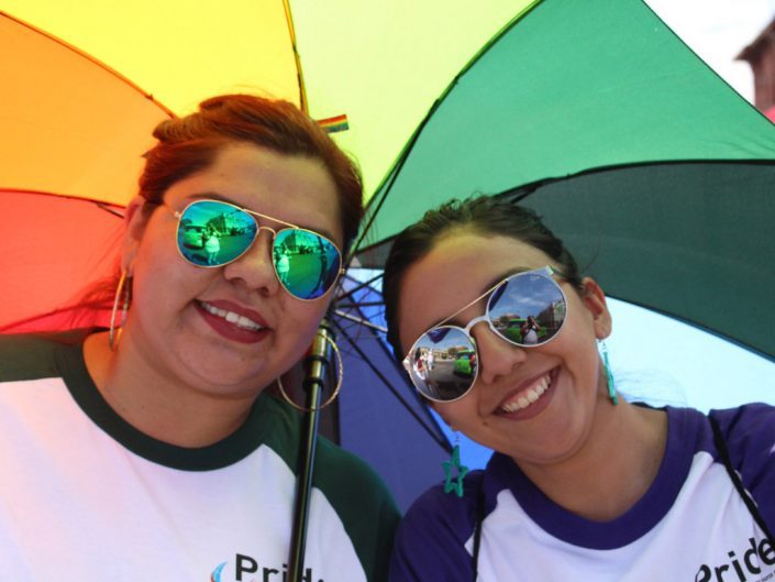 dvě zaměstnankyně ADP pod deštníkem v barvách duhy