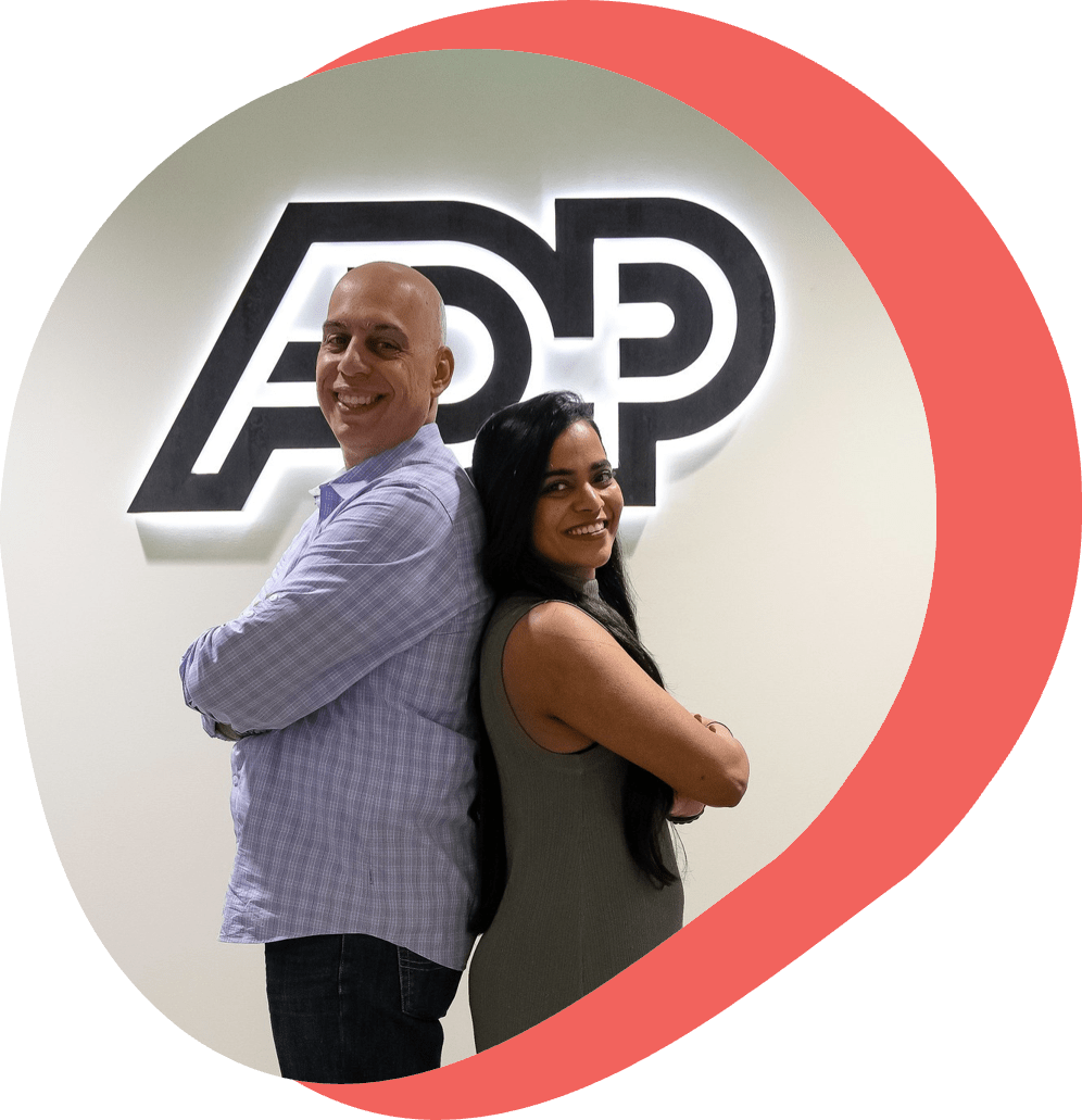 4_main-page-1 man and woman standing back to back in front of ADP logo, smiling at camera